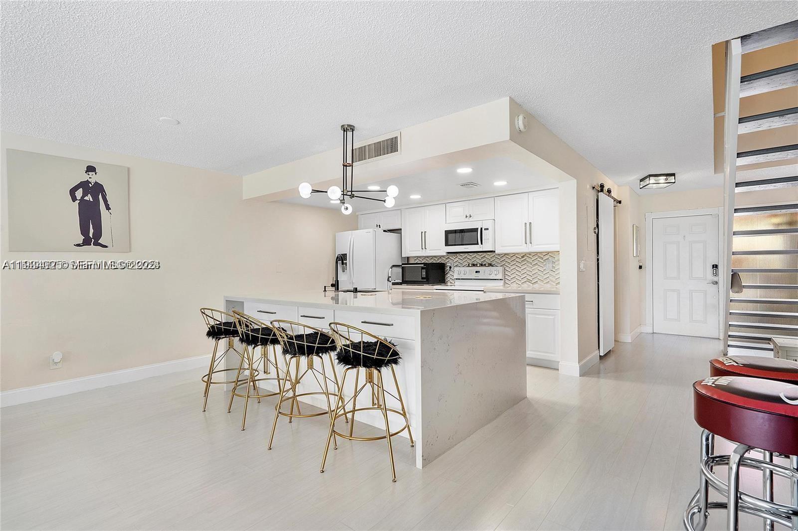 1281 West Fairway Road Pembroke Pines, FL 33026 - Photo 10 of 29 a kitchen with kitchen island granite countertop a sink cabinets and stainless steel appliances