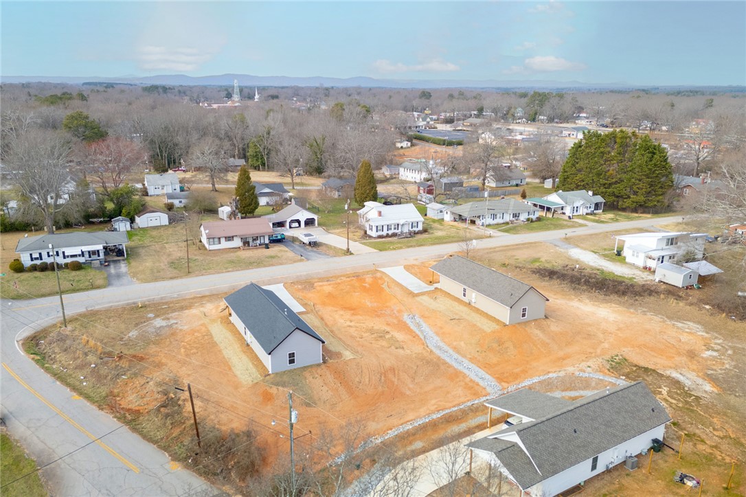 115 Riley Street Westminster, SC 29693 - Photo 30 of 46 An aerial view showcases a vibrant community with diverse homes nestled among trees and rolling hills.