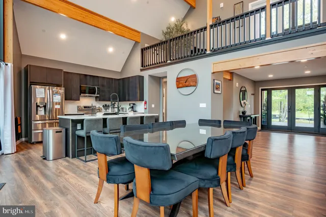 a bedroom with a bed a mirror on the dresser and a table