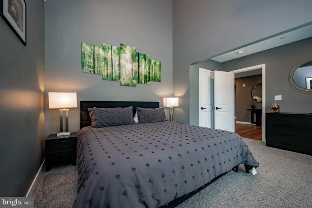 a bedroom with a bed and a painting on the wall