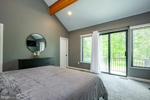 a living room with furniture a flat screen tv and a large window