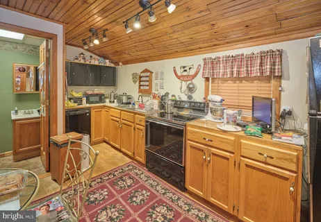 a kitchen with stainless steel appliances granite countertop a stove a sink dishwasher and cabinets with wooden floor