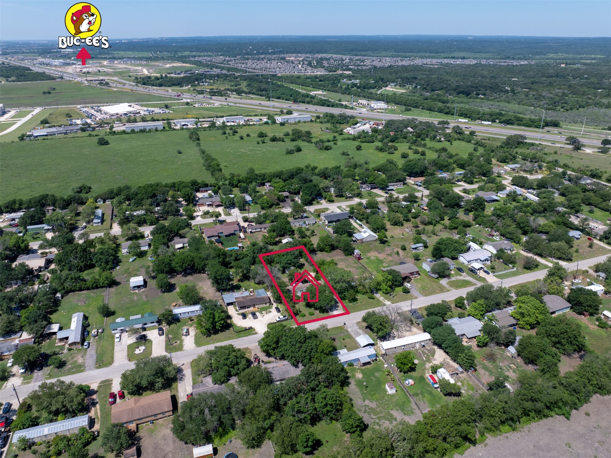 258 Quail Ridge Drive Kyle, TX 78640 - Photo 3 of 11 Aerial perspective showcasing a property outlined in red, surrounded by mature trees and residential structures