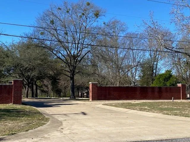 a view of a yard with wooden fence