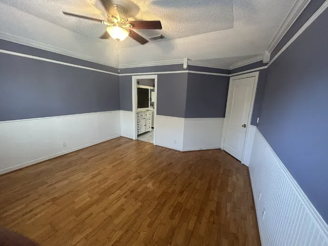 a bedroom with a bed and a chandelier fan