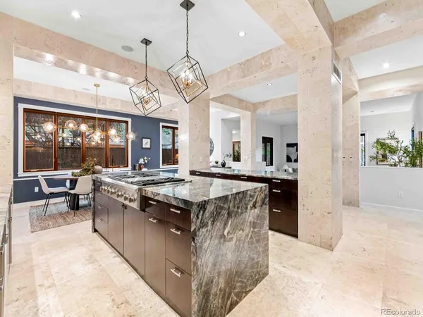 a large kitchen with a stove a kitchen island a dining table and chairs
