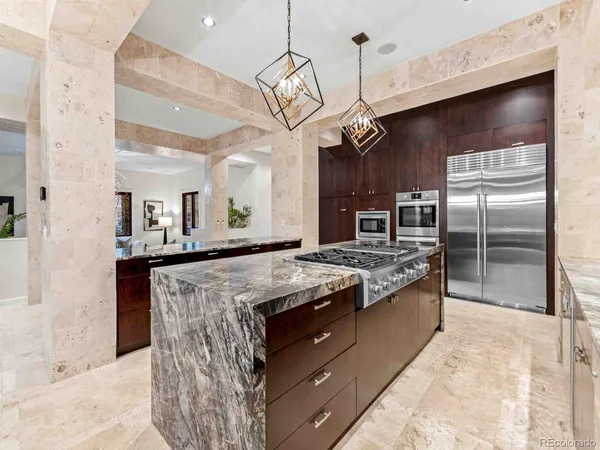 a kitchen with stainless steel appliances granite countertop a sink a stove and a refrigerator