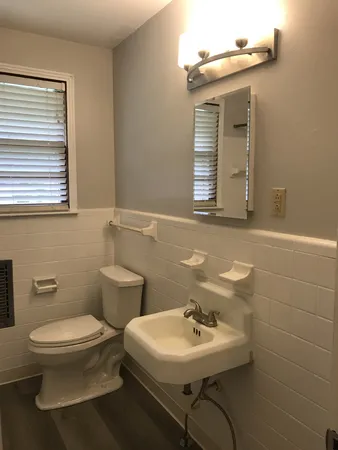 a bathroom with a toilet sink and mirror