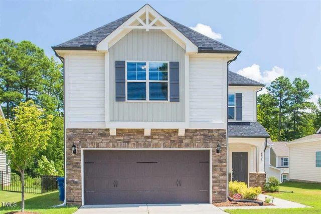 a front view of a house with a yard garage and outdoor seating
