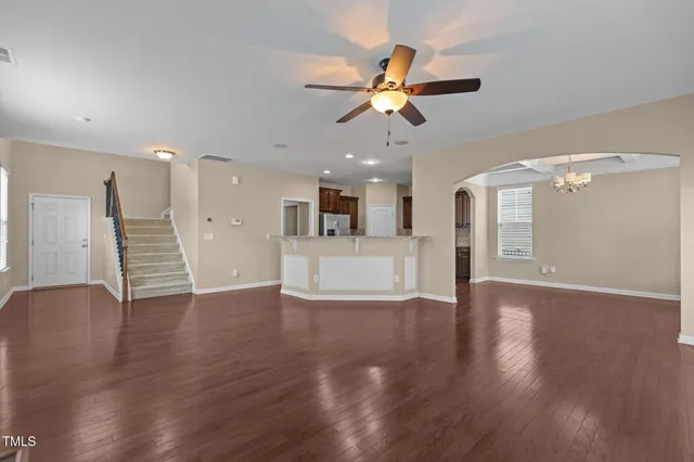 a view of a livingroom with a ceiling fan wooden floor and window