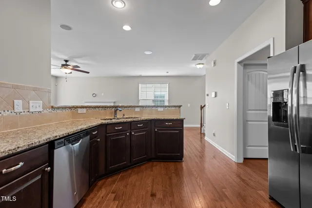 a large kitchen with stainless steel appliances granite countertop a sink and wooden floor
