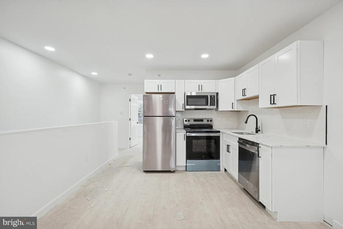 a kitchen with cabinets and stainless steel appliances