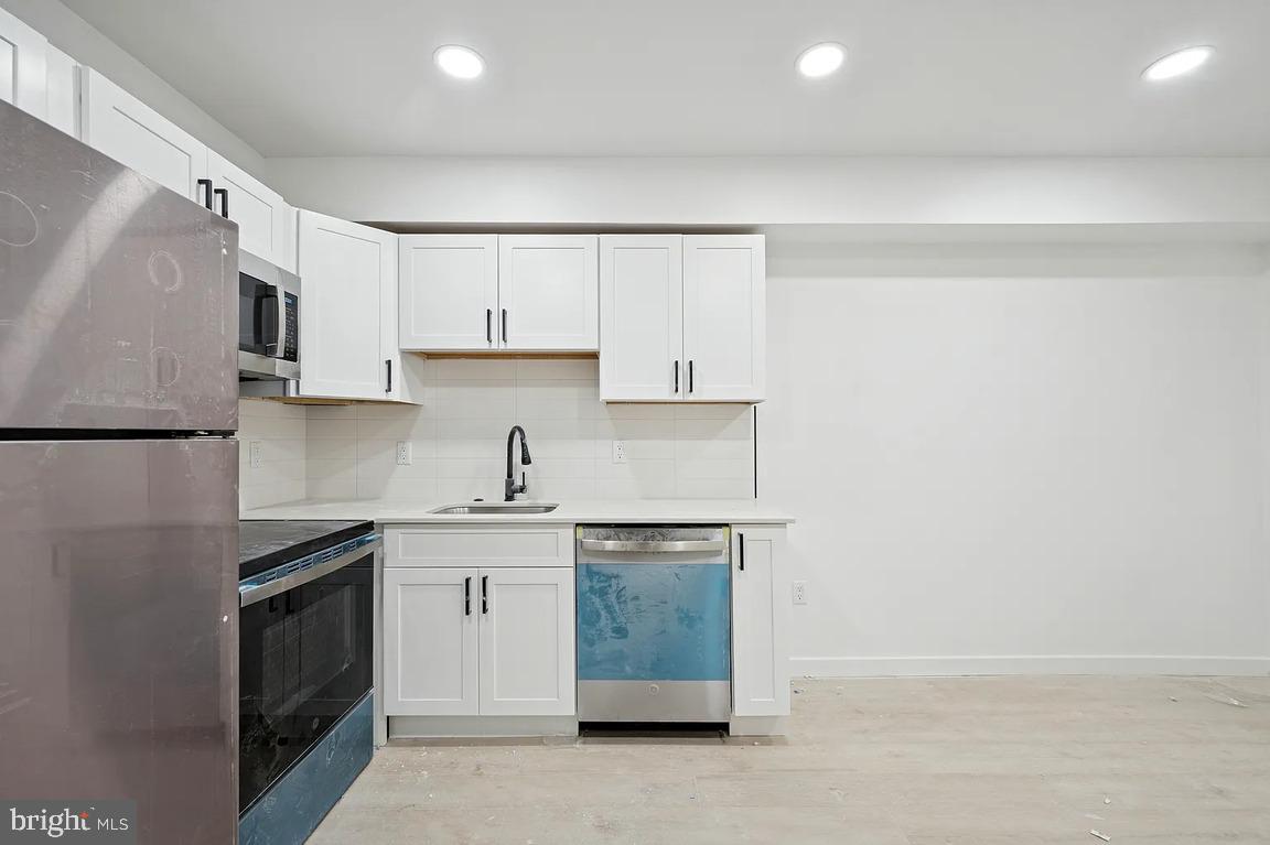 52 North 51st Street, Unit 2 Philadelphia, PA 19139 - Photo 2 of 8 a kitchen with stainless steel appliances granite countertop a stove a sink and a refrigerator