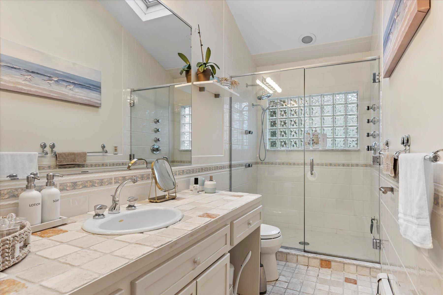 3 Crestview Drive Remsenburg, NY 11960 - Photo 10 of 21 Full bathroom featuring toilet, tile walls, vanity, and a stall shower