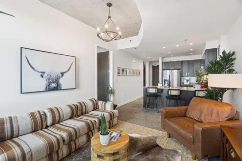 a living room with furniture kitchen and a chandelier