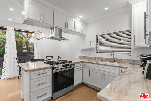 a kitchen with stainless steel appliances granite countertop a sink and a stove