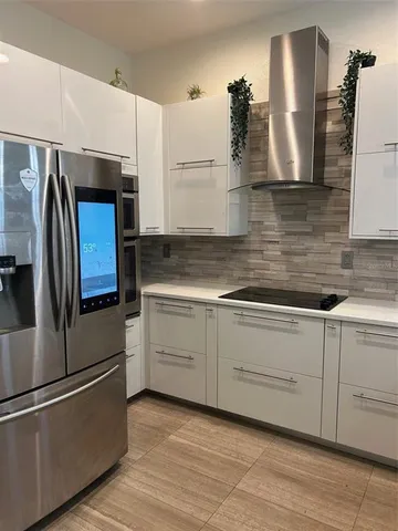 a kitchen with stainless steel appliances granite countertop a refrigerator and a sink