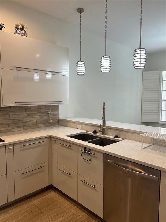 3436 Primrose Way Palm Harbor, FL 34683 - Photo 6 of 16 a kitchen with a sink and dishwasher with white cabinets
