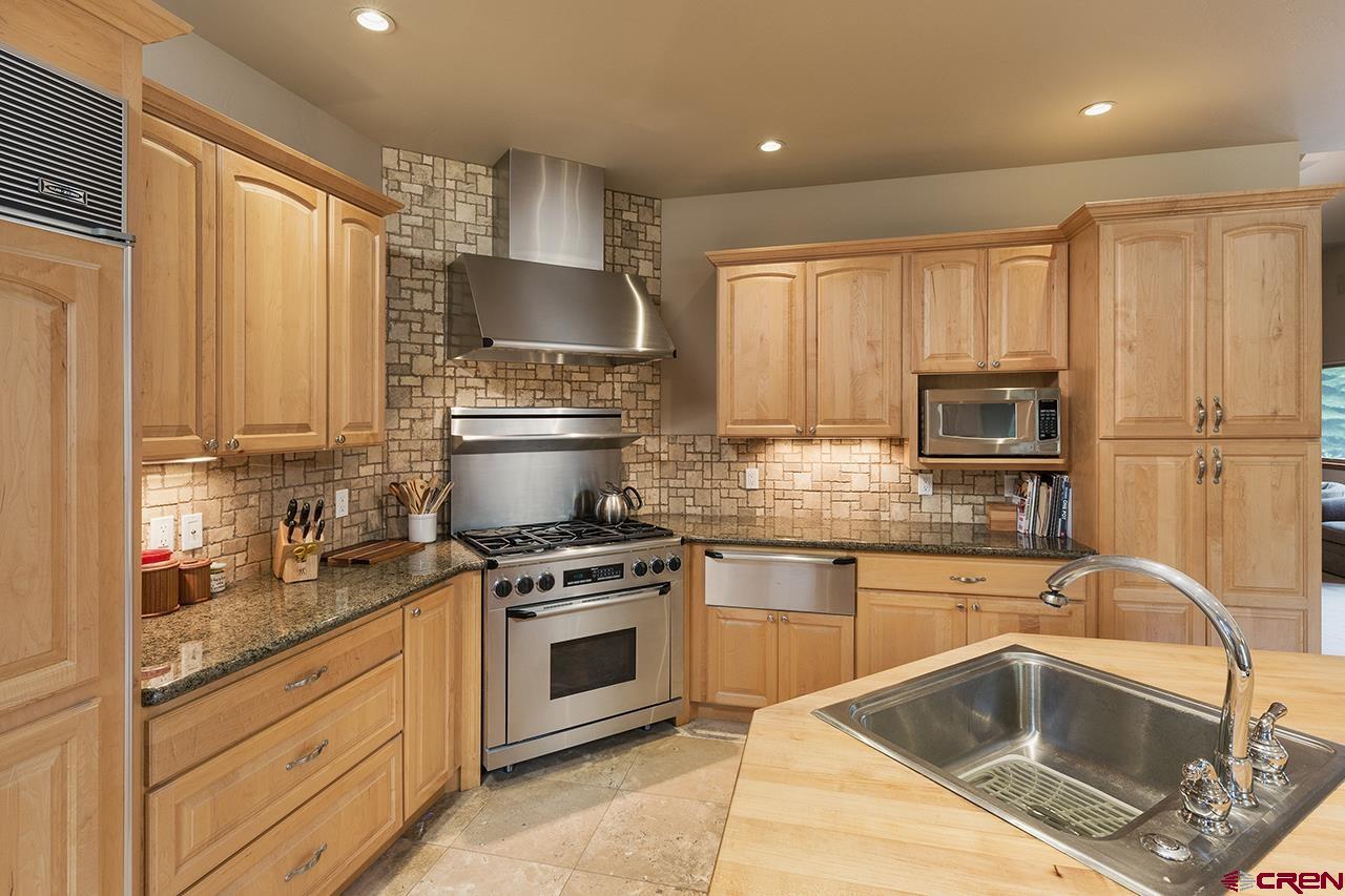 435 Red Rock Road Durango, CO 81301 - Photo 14 of 35 a kitchen with granite countertop a stove sink and refrigerator