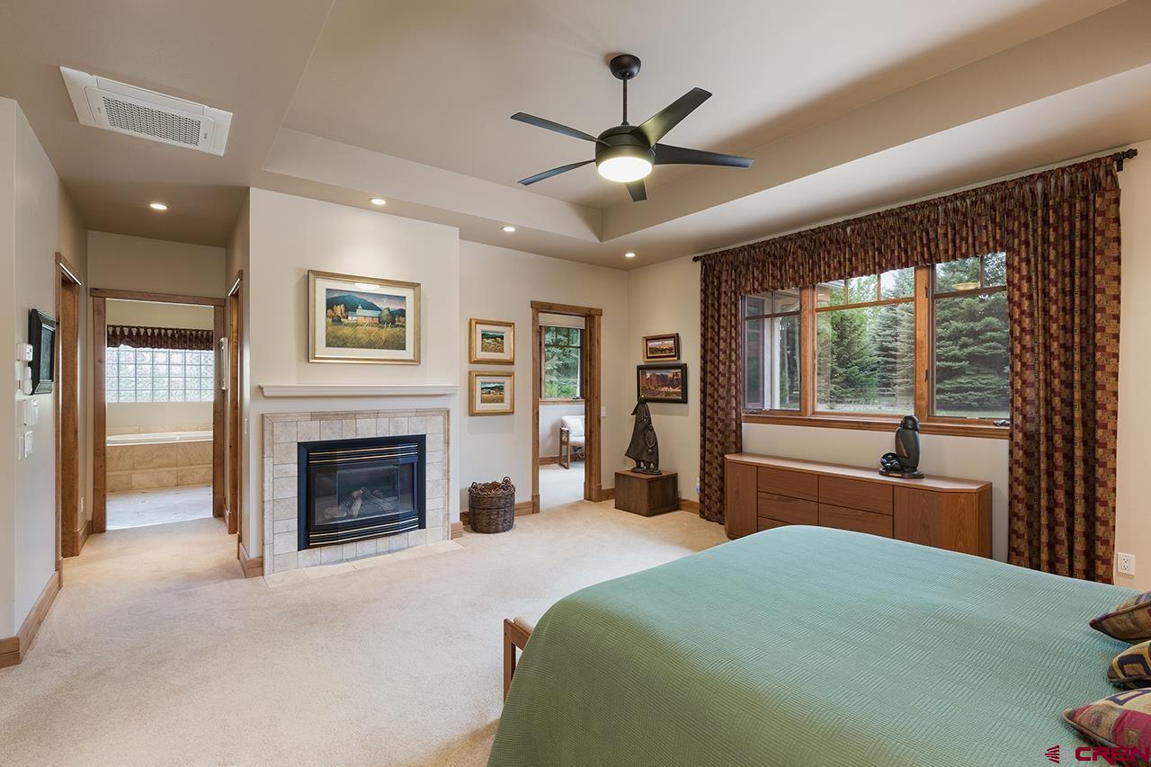 435 Red Rock Road Durango, CO 81301 - Photo 18 of 35 a bedroom with a bed and a fireplace
