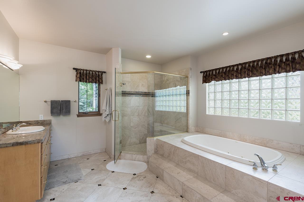435 Red Rock Road Durango, CO 81301 - Photo 22 of 35 a bathroom with a granite countertop sink a toilet and shower