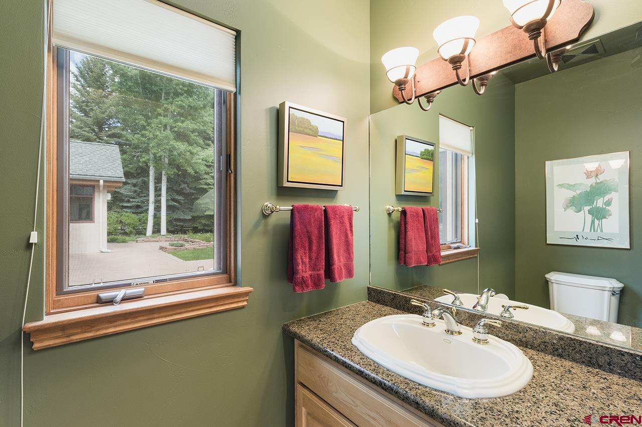 435 Red Rock Road Durango, CO 81301 - Photo 29 of 35 a bathroom with a granite countertop sink and a large mirror