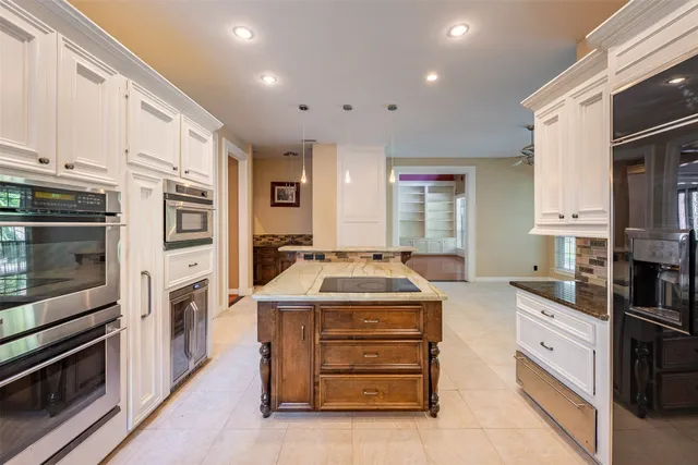 a kitchen with stainless steel appliances granite countertop a refrigerator and a stove top oven