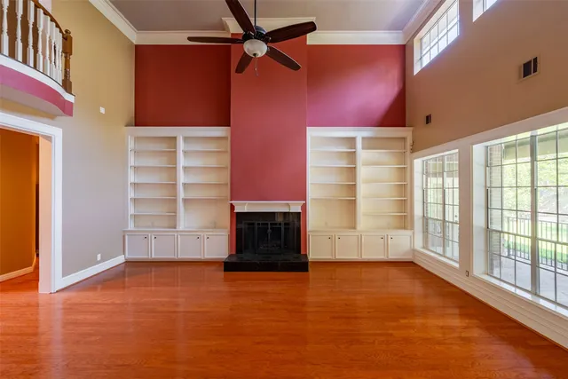 a view of empty room with a fireplace and wooden floor
