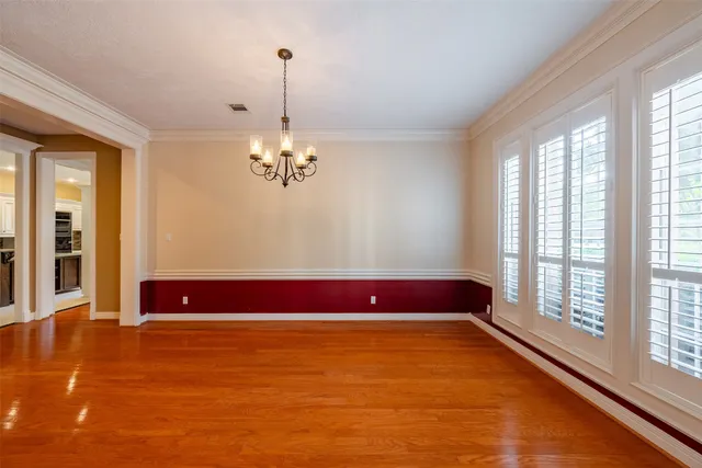a view of an empty room with window chandelier