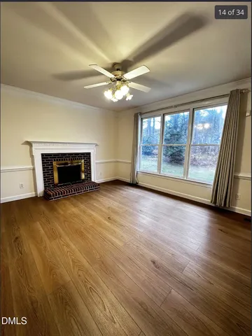 wooden floor fireplace and windows in an empty room