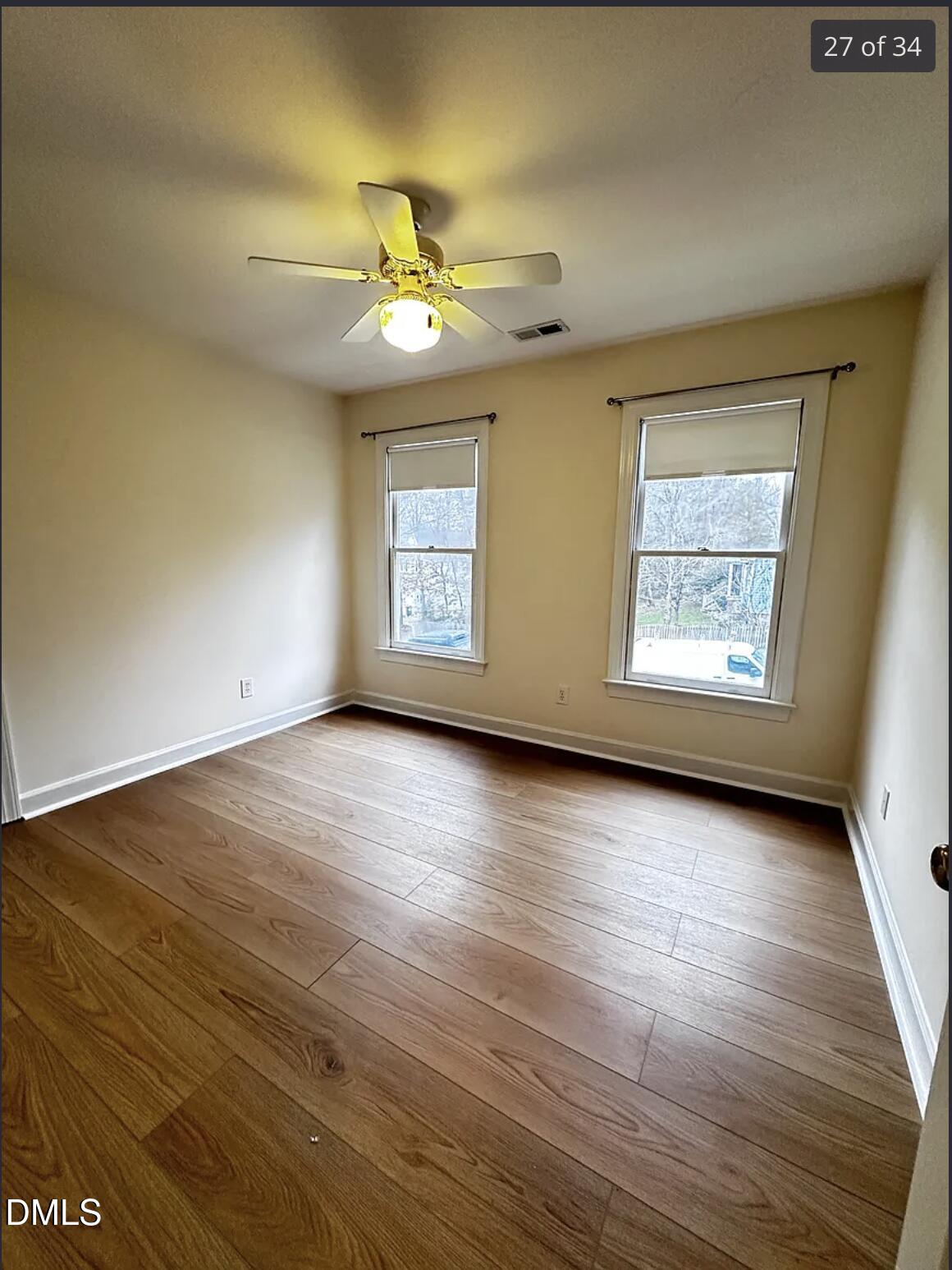 214 Cobble Ridge Drive Chapel Hill, NC 27516 - Photo 28 of 34 an empty room with wooden floor chandelier fan and windows