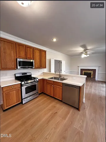 a large kitchen with stainless steel appliances granite countertop a stove a sink dishwasher a microwave oven with cabinets and wooden floor