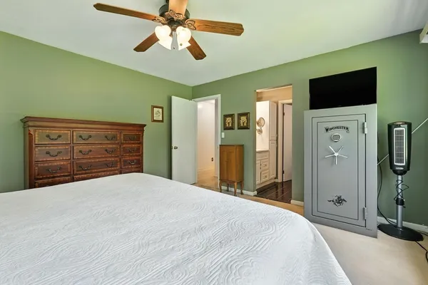 a bedroom with a bed and a flat tv screen on dresser