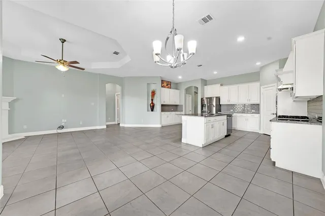 a large white kitchen with stainless steel appliances cabinets a sink and a counter top space