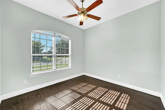 a view of an empty room with window and a kitchen