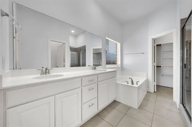 a spacious bathroom with a granite countertop sink mirror and bathtub