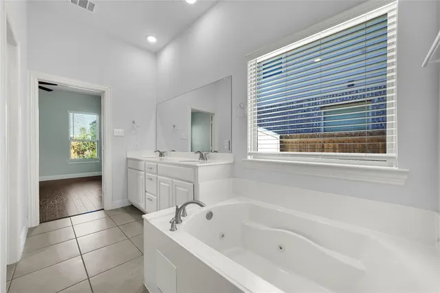 a bathroom with a bathtub sink and mirror