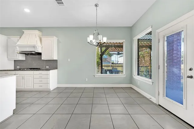 a open kitchen with granite countertop white cabinets stainless steel appliances a sink and a window