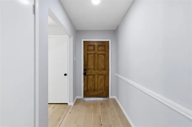 a view of a hallway with wooden floor