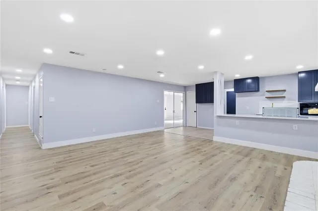 a view of kitchen with kitchen island granite countertop cabinets and refrigerator