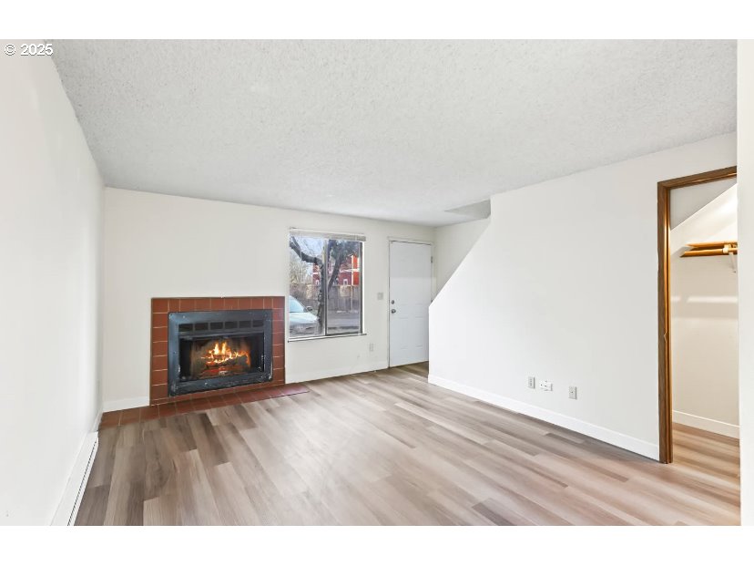 15 Northeast 127th Avenue Portland, OR 97230 - Photo 7 of 8 a view of an empty room with wooden floor and a fireplace