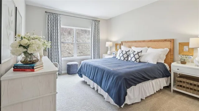 a bedroom with a bed and a large window