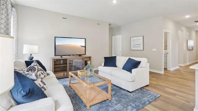 a living room with furniture and wooden floor