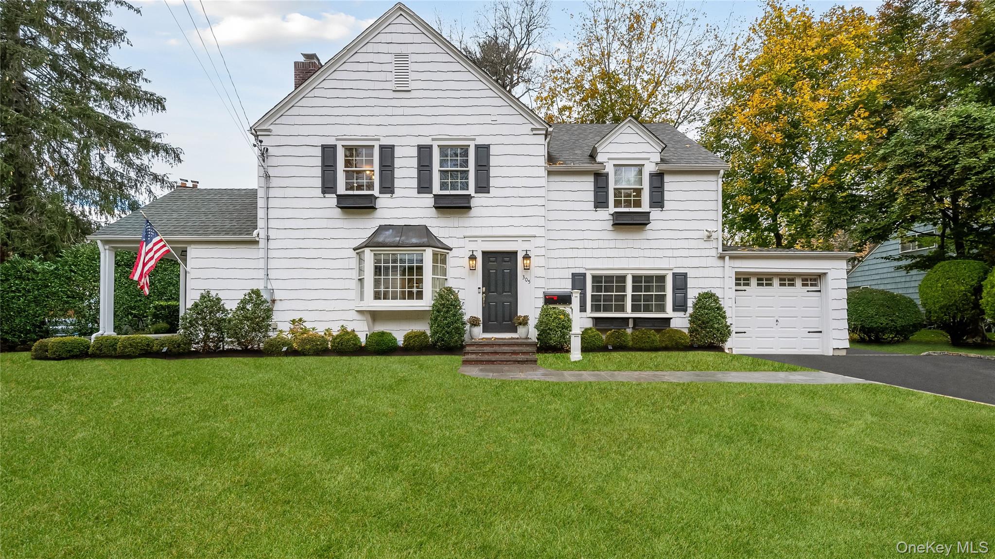 a front view of a house with a garden and yard