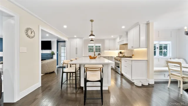 a living room with kitchen island furniture a dining table wooden floor and a large window