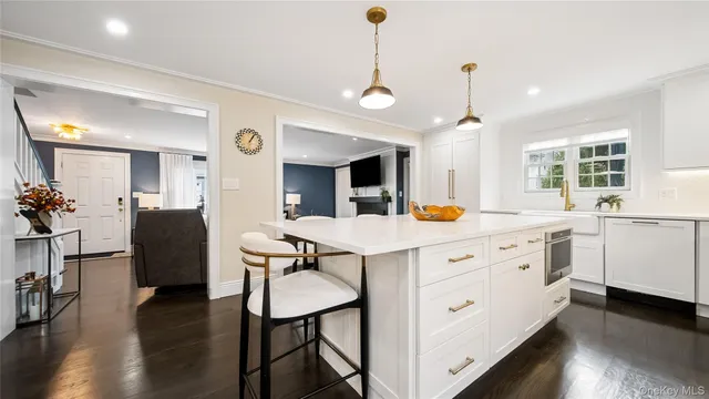 a kitchen with stainless steel appliances granite countertop a stove a sink a dining table and chairs with wooden floor