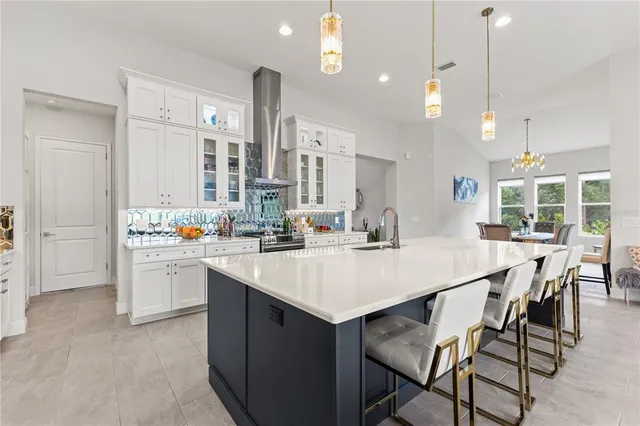 a view of a dining room with furniture a chandelier and a window