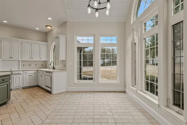 a large white kitchen with cabinets