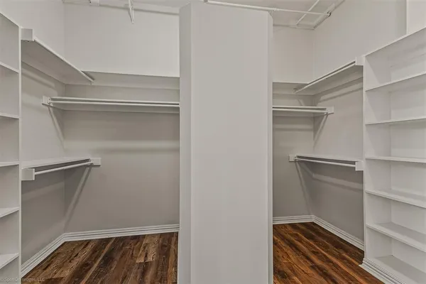 a room with walk in closet and wooden floor