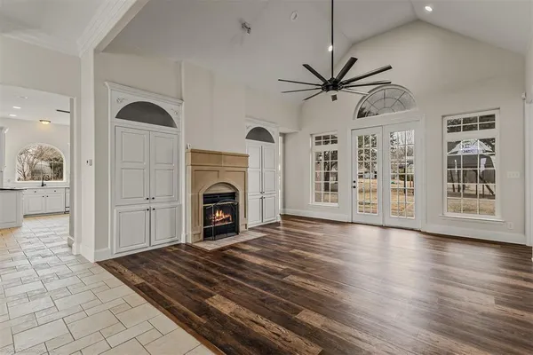 a view of a livingroom with a fireplace a chandelier and wooden floor